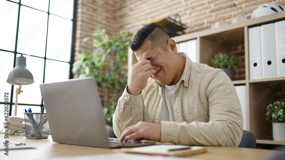 Young hispanic man business worker stressed using laptop at office Young hispanic man business worker stressed using laptop at office