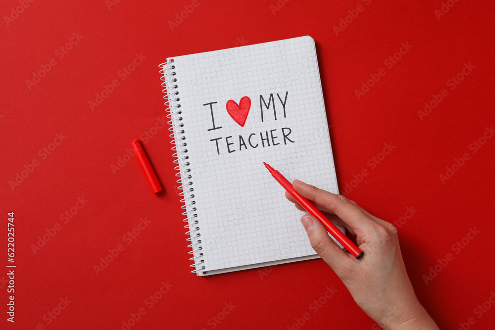 Notepad and female hand with marker on red background Notepad and female hand with marker on red background