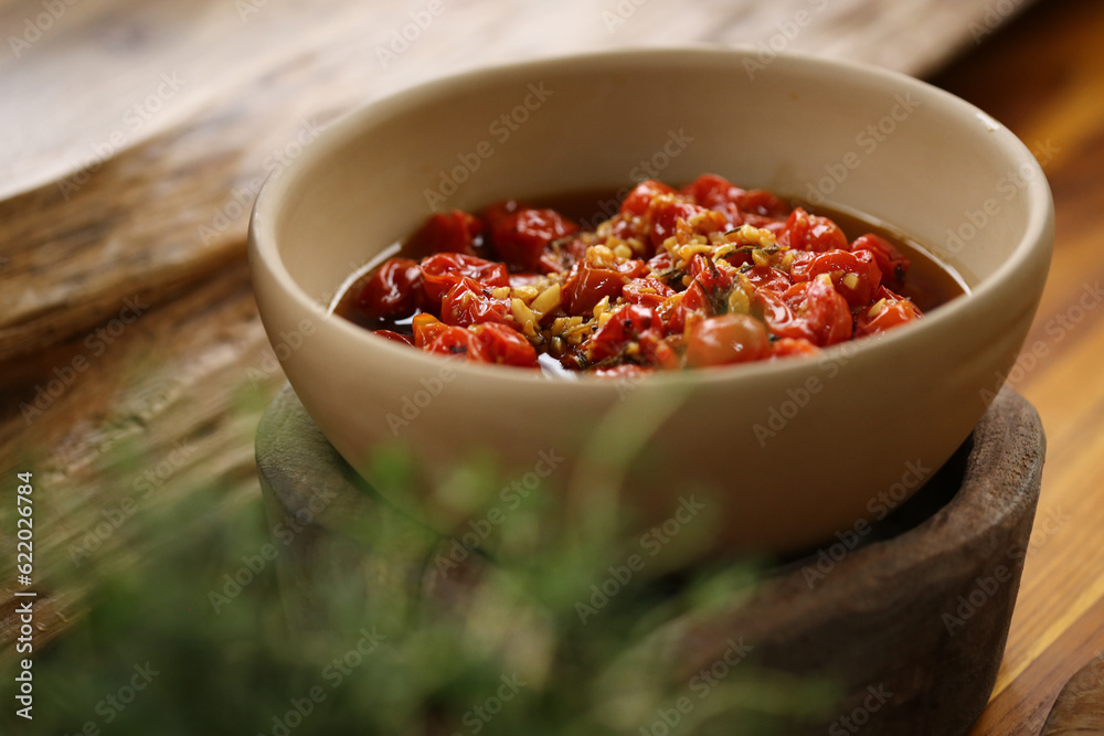 tomatinhos confit com alho em laminas dourados, servido como aperitivo em um evento delicioso tomatinhos confit com alho em laminas dourados, servido como aperitivo em um evento delicioso