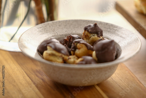 Pequenas carolinas, deliciosas minibombas de creme de chocolate, uma tradicional sobremesa francesa, servidas com elegância em um evento de café da manhã.