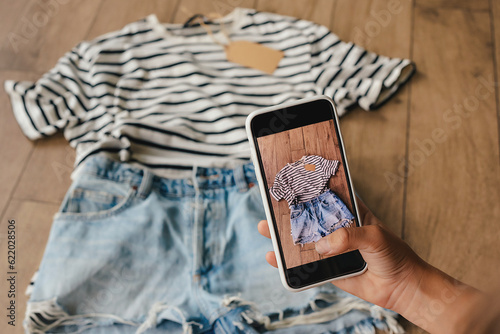 Woman taking picture of used clothes. Selling used clothes concept.