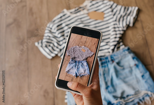 Woman taking picture of used clothes. Selling used clothes concept. photo