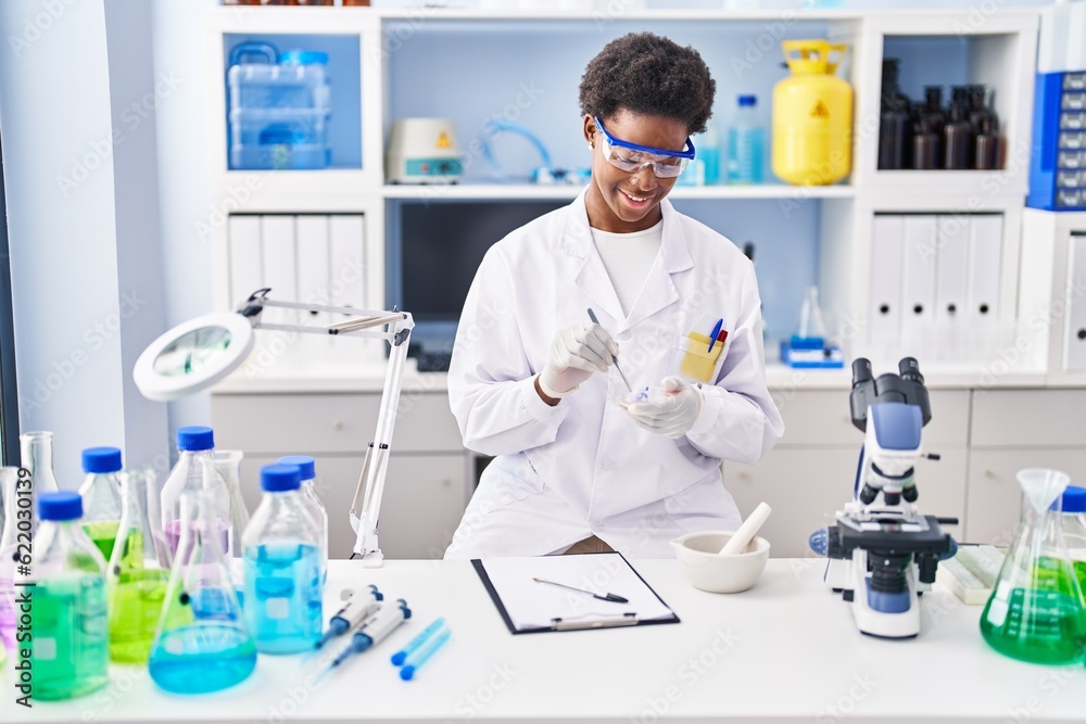 African american woman wearing scientist uniform working at laboratory African american woman wearing scientist uniform working at laboratory