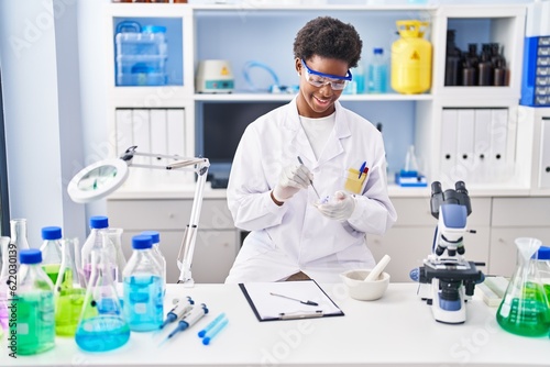 African american woman wearing scientist uniform working at laboratory