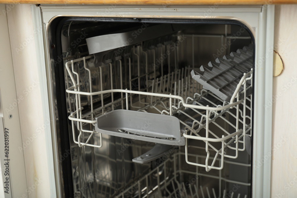 Open dishwasher with metal shelves for dishes Open dishwasher with metal shelves for dishes