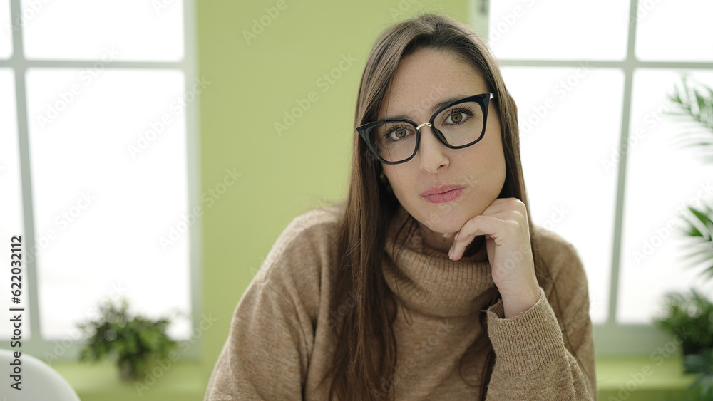 Beautiful hispanic woman sitting with relaxed expression at home Beautiful hispanic woman sitting with relaxed expression at home