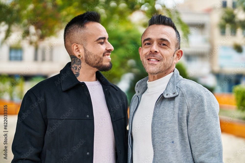 Two men couple smiling confident standing together at park Two men couple smiling confident standing together at park