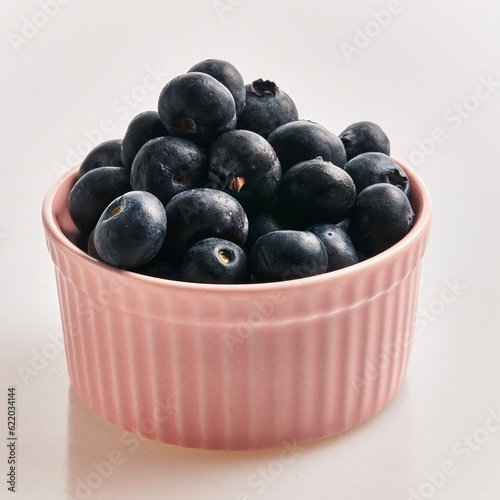  Delicious group of blueberries on ceramic bowl over isolated white background