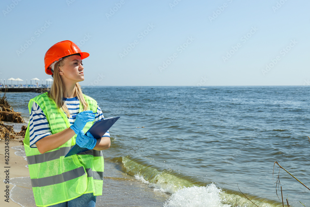 A woman in a hard hat investigates river pollution