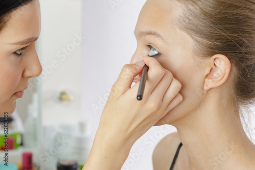 novice make-up artist applies make-up to model