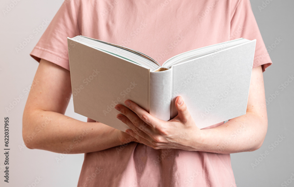 Obraz premium Hand holding white open book, reader student