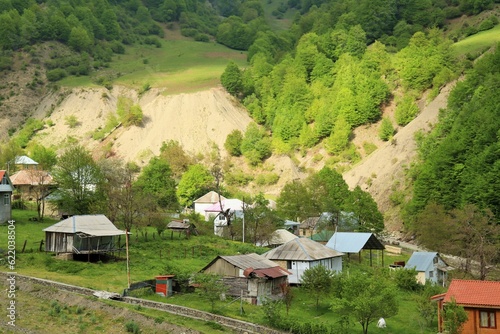 Landscape village at the foot of the mountains covered with dense lush green vegetation