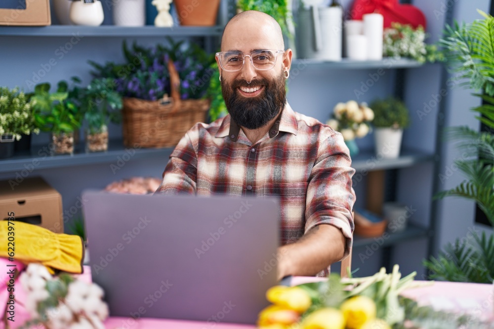 Young bald man florist smiling confident using laptop at flower shop Young bald man florist smiling confident using laptop at flower shop