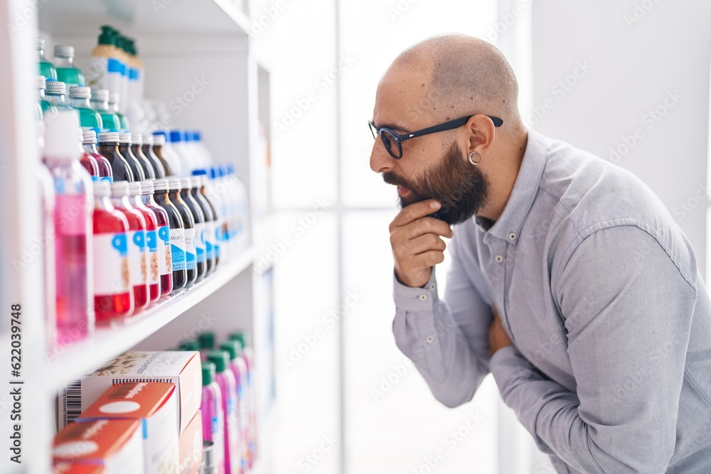 Young bald man customer looking shelving at street