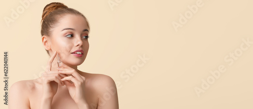 Beautiful young woman with ampule on beige background with space for text. Cosmetology concept