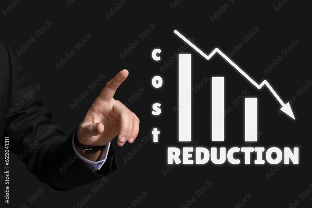Businessman using virtual screen on dark background. Cost reduction Businessman using virtual screen on dark background. Cost reduction