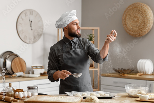 Male baker sprinkling raw b...