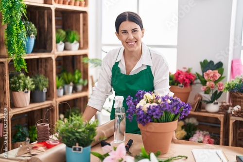 Young beautiful hispanic woman florist smiling confident standing at flower shop