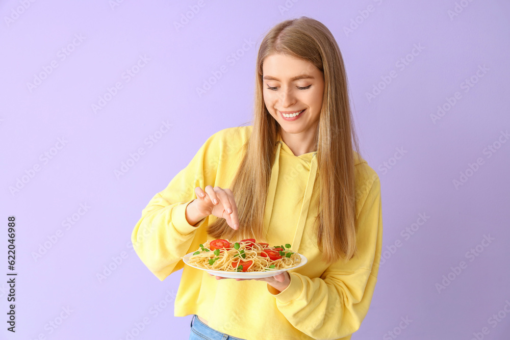 Young woman with tasty pasta on lilac background Young woman with tasty pasta on lilac background