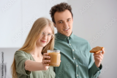 Young woman holding jar of ...