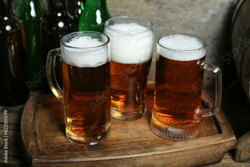 Mugs and glass of cold beer on wooden background. Oktoberfest celebration