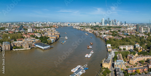 Beautiful panoramic view of London Thames river with Canary Wharf skyline in the background. Beautiful London district. © Aerial Film Studio