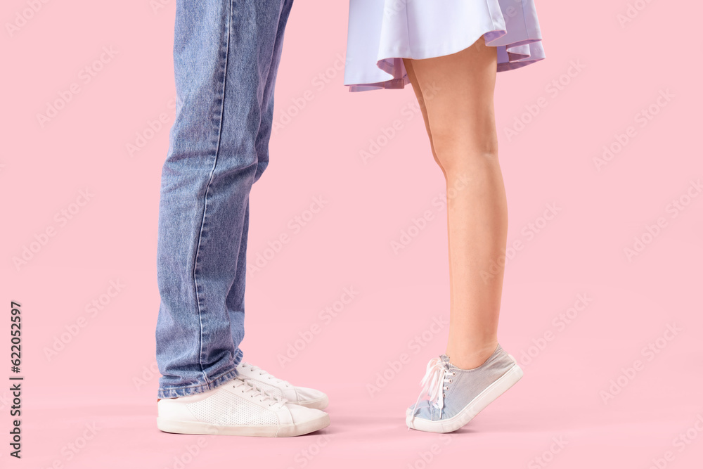 Happy young couple kissing on pink background Happy young couple kissing on pink background