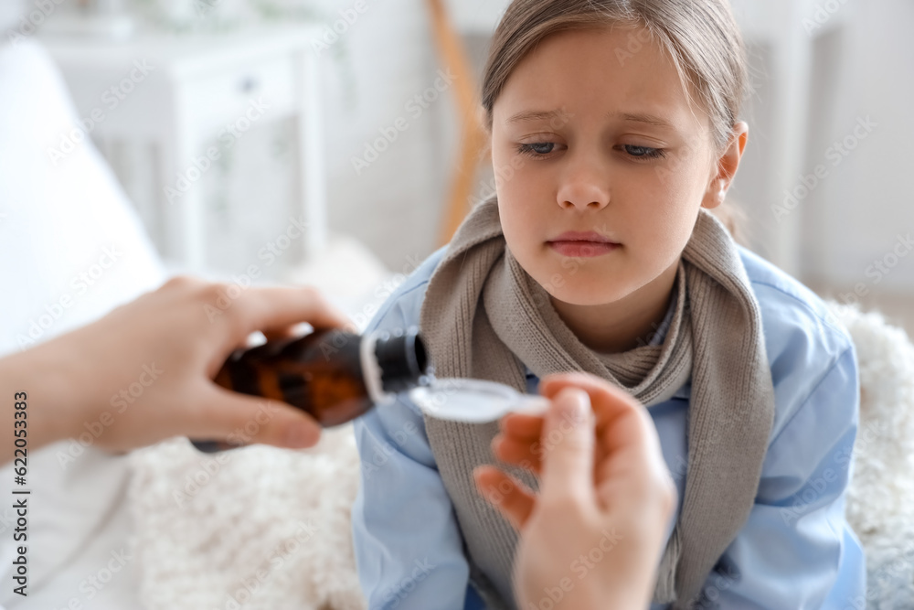 Ill little girl taking cough syrup in bedroom, closeup Stock Photo