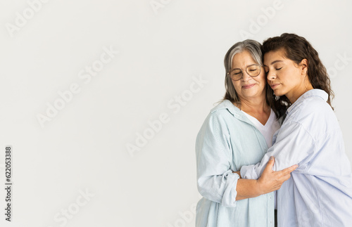 Calm happy adult woman hugging old lady, enjoy free time, visit, isolated on white studio background