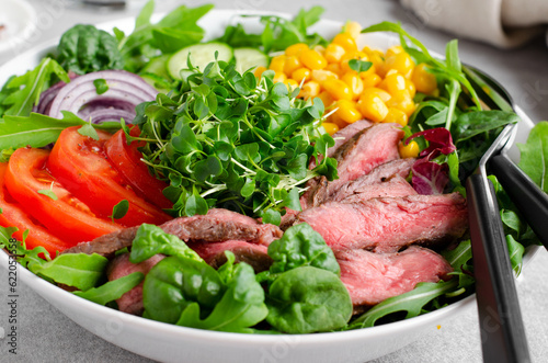 Beef steak and Fresh Vegetables Buddha Bowl, Healthy Balanced Meal on Bright Background