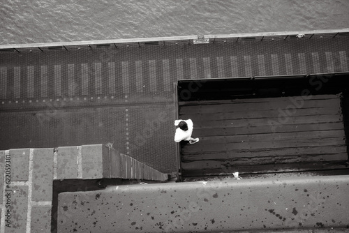 Grayscale top view of a person standing on the waterside building photo