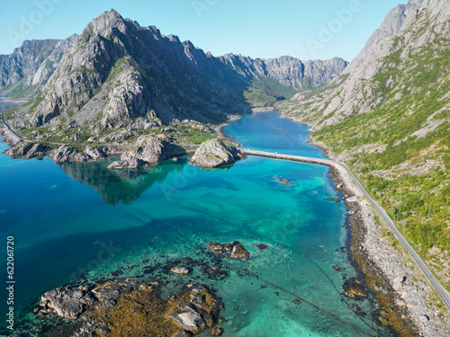 une route en scandinavie entre grandes montagnes et eaux bleues transparentes