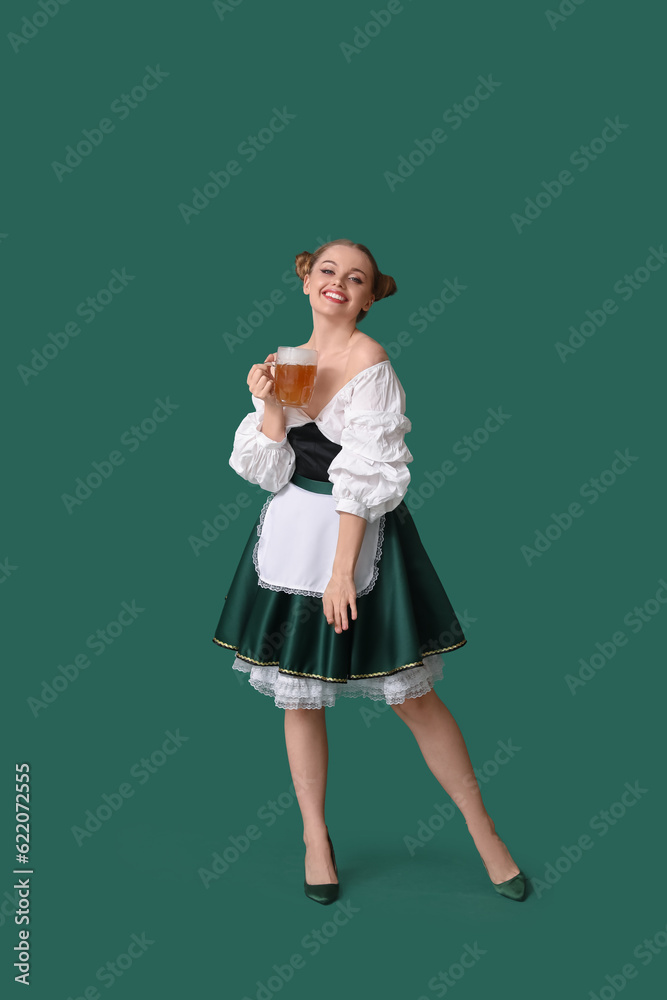 Beautiful Octoberfest waitress with beer dancing on green background Beautiful Octoberfest waitress with beer dancing on green background