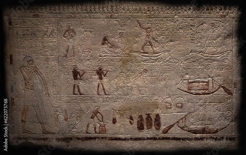 An Egyptian stone tablet isolated on a black background, on which scenes from mythology are drawn, and numerous hieroglyphs, symbols and inscriptions are engraved.