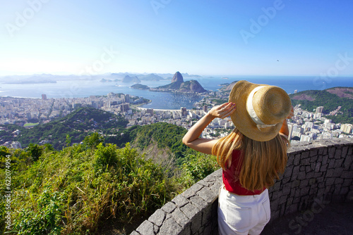 Aerial view of stylish girl holding hat on Rio de Janeiro viewpoint with Guanabara Bay  Rio de Janeiro  Brazil