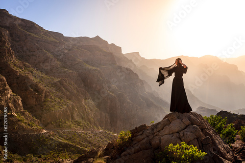 Lone woman in abaya in Al Hajar Mountains of Oman at sunset © Designpics