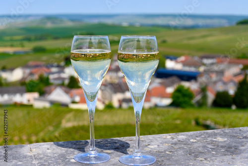 Tasting of grand cru sparkling white wine with bubbles champagne with view on houses and vineyards grand cru wine producer small village Cramant  Champagne  France