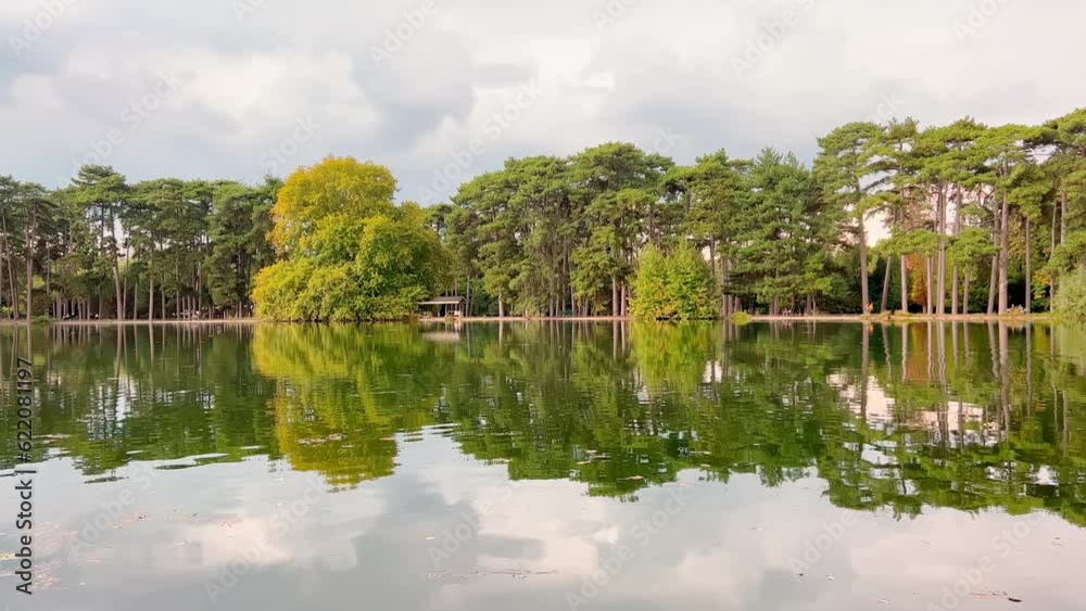 France, Paris, Magic mirror reflection of green tree in lake in the Bois de Boulogne at cloudy weather, peace and quiet France, Paris, Magic mirror reflection of green tree in lake in the Bois de Boulogne at cloudy weather, peace and quiet