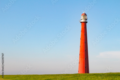 Beautiful Red Lighthouse under a blue sky shot at sunset in Den Helder  The Netherlands.