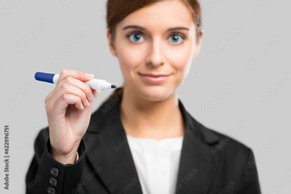 Beautiful businesswoman drawing on a glass board with a marker Beautiful businesswoman drawing on a glass board with a marker