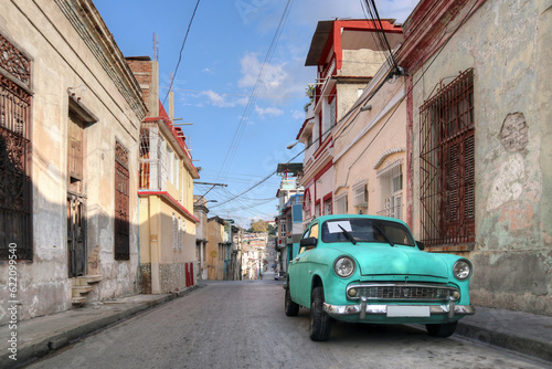 A green classic car on the street of Santiago De Cuba