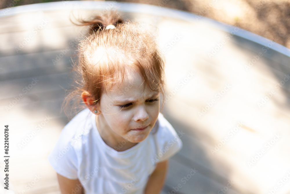 Portrait of a little girl playing on the playground in summer day Portrait of a little girl playing on the playground in summer day