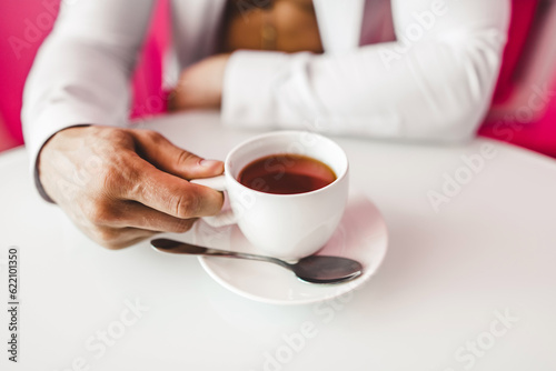 Man in shirt with white cup in the kitchen close up