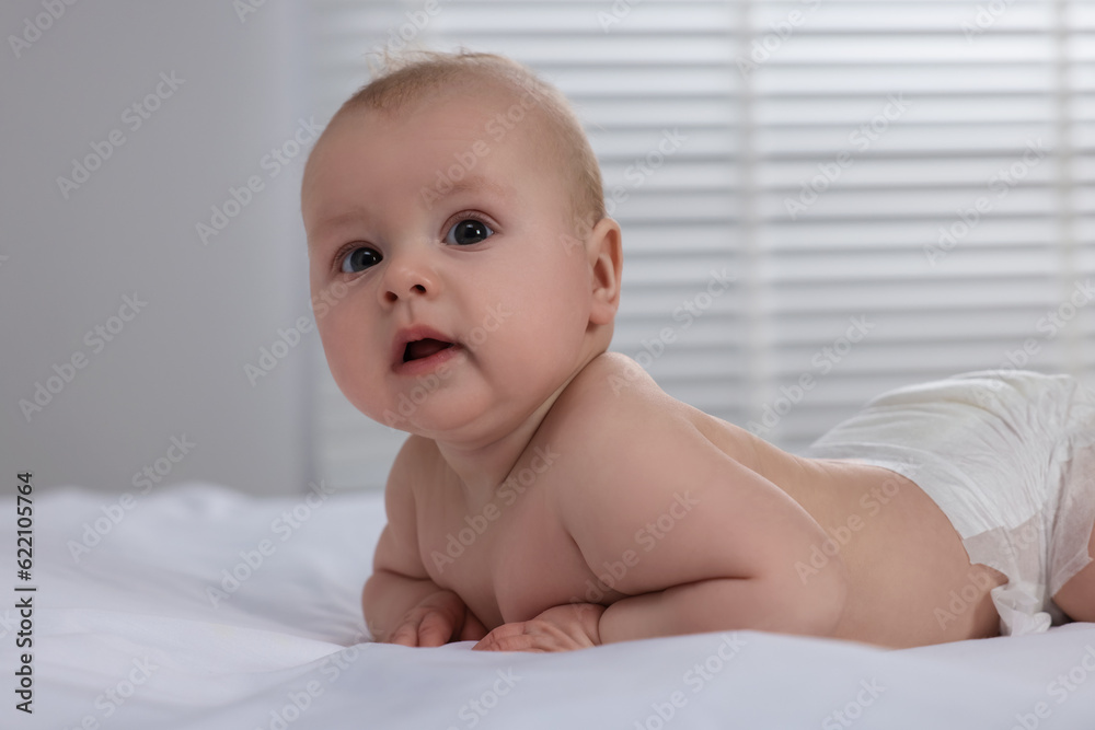 Cute little baby in diaper lying on bed indoors Cute little baby in diaper lying on bed indoors