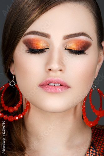 Beautiful young woman with bright orange makeup. Beauty shot. Closeup.