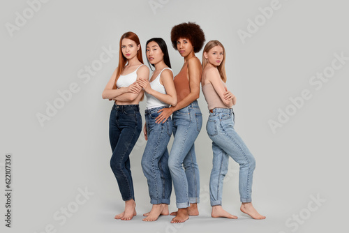 Group of beautiful young women on light grey background