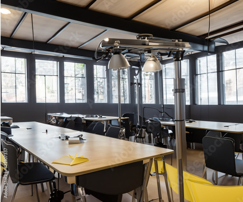 wide angle view of a modern classroom, tables and chairs with led lighting