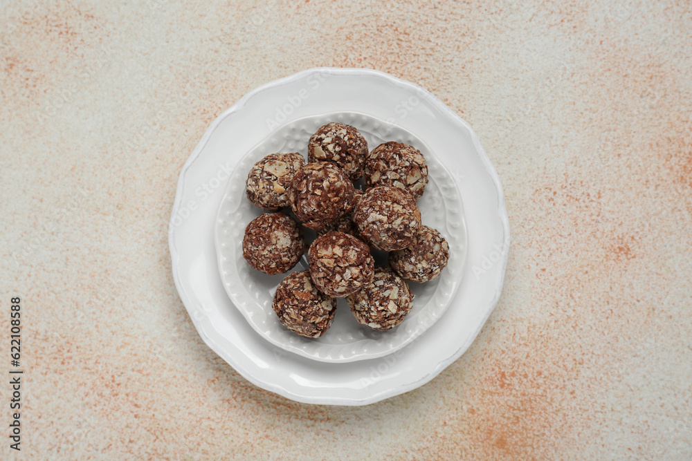 Delicious chocolate candies on beige table, top view Delicious chocolate candies on beige table, top view