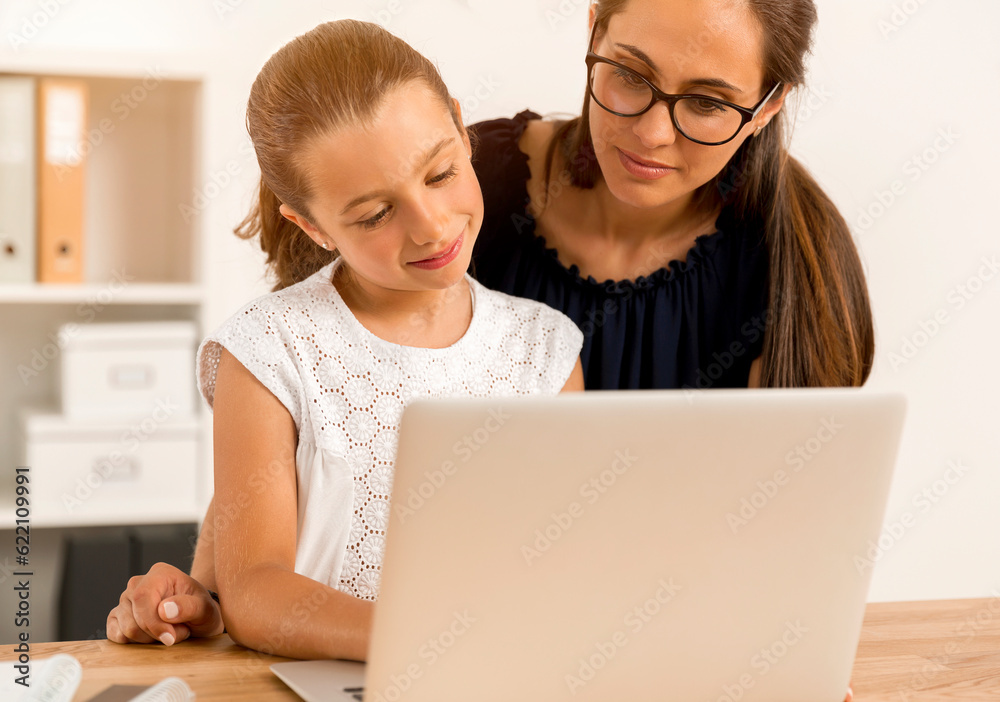 Mother helping her little daughter how to use a computer Mother helping her little daughter how to use a computer