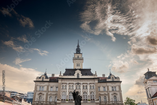 Trg Slobode Square with the city hall, or Gradska Kuca, and the Svetozar Miletic statue created in 1935 by Ivan mestrovic in novi sad, second biggest city of Serbia, with people passing by. photo